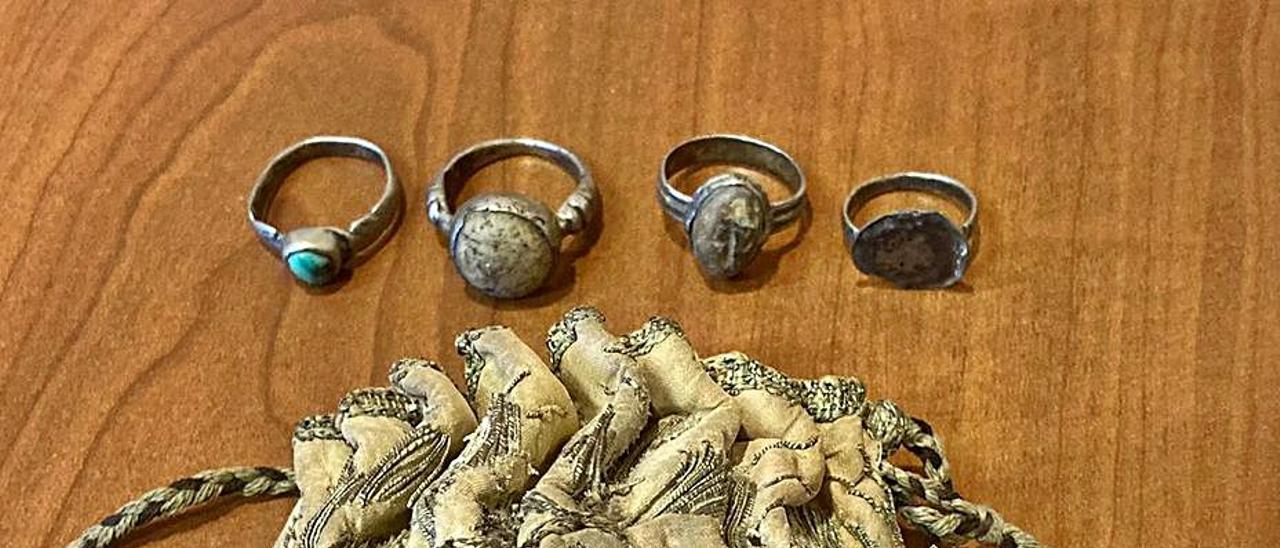 Los cuatro anillos encontrados en el monasterio de San Estevo. A la derecha, los pergaminos que acreditan su autenticidad. |   // FDV