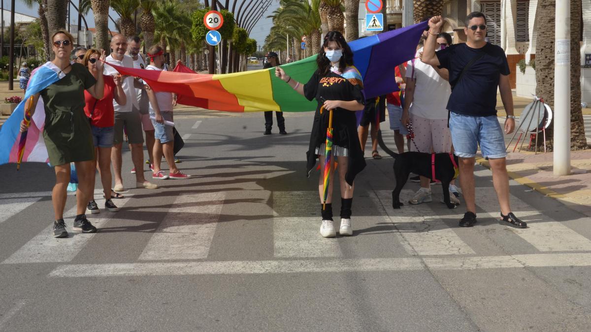 Un grupo de personas sostiene la bandera arcoíris que ha recorrido la avenida Mare Nostrum de Moncofa.