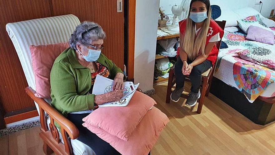 Voluntaria de Cruz Roja con una mujer en Palma.