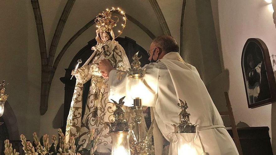 El sacerdote Florentino Hoyos coloca el rosario a la imagen de la Virgen de Guía, ayer en la basílica de Llanes.