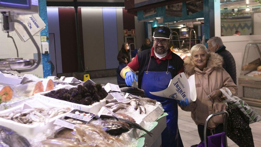 El pescadero avilesino Juan Ferrero atiende a una de sus clientas en la plaza de abastos de Avilés. | María Fuentes