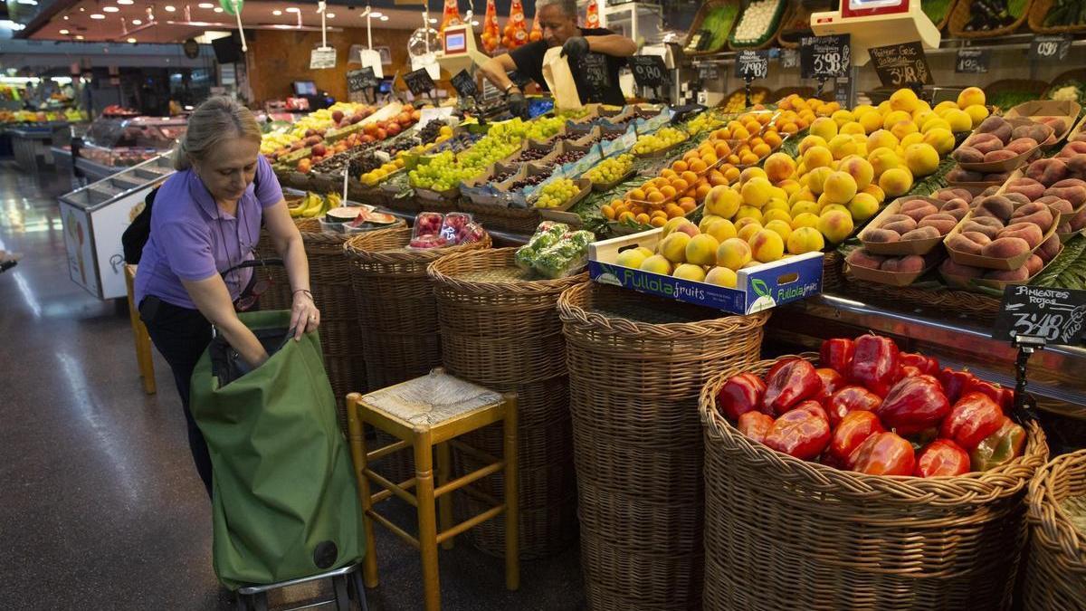La mujer compra fruta en un mercado municipal de Barcelona.
