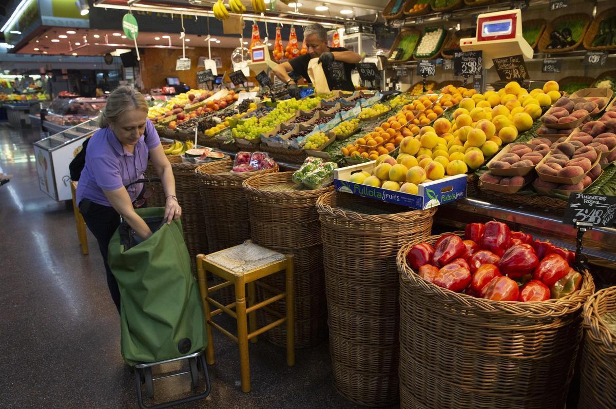 La mujer compra fruta en un mercado municipal de Barcelona.