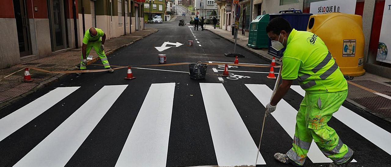 Varios trabajadores pintan el paso de peatones en el entronque de la calle Gijón con Conde Real Agrado. | M. V.