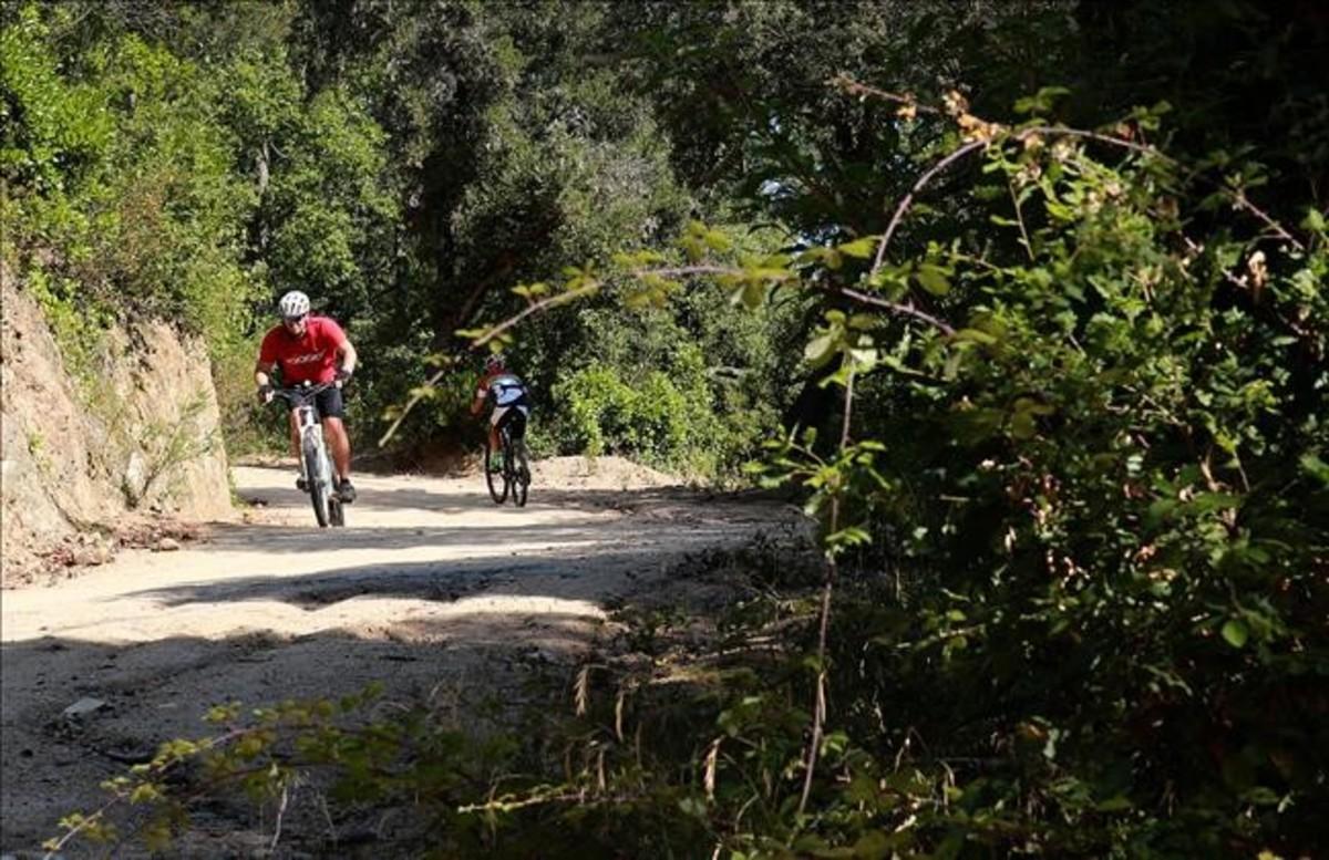 Dos aficionados al mundo del pedal se cruzan en un camino de tierra de la ’serralada’ de Marina, a la altura de Sant Fost de Campsentelles. 