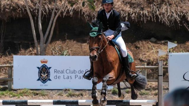 Una de las amazonas en pleno salto de las barras junto a su caballo. |