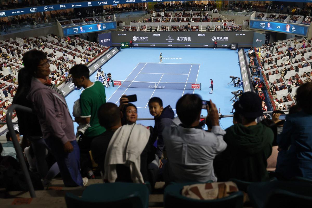 Aficionados chinos se fotografían desde la grada durante el partido