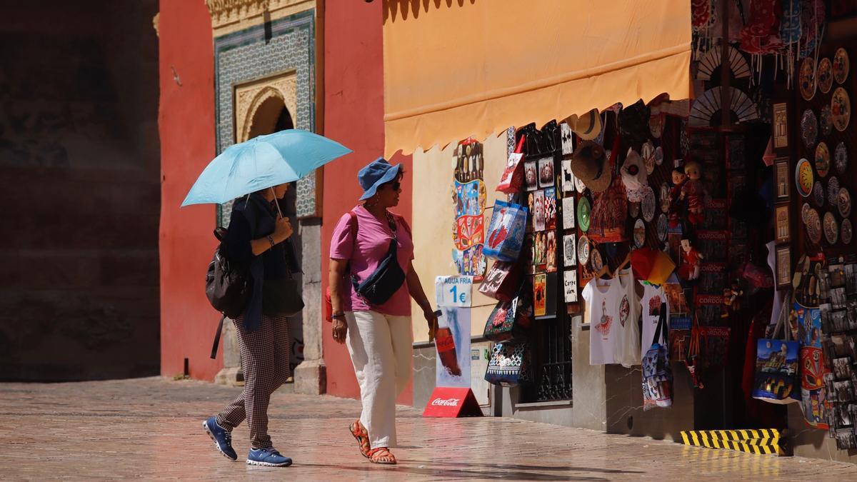 Turistas en el entorno de la Mezquita-Catedral se protegen del calor.