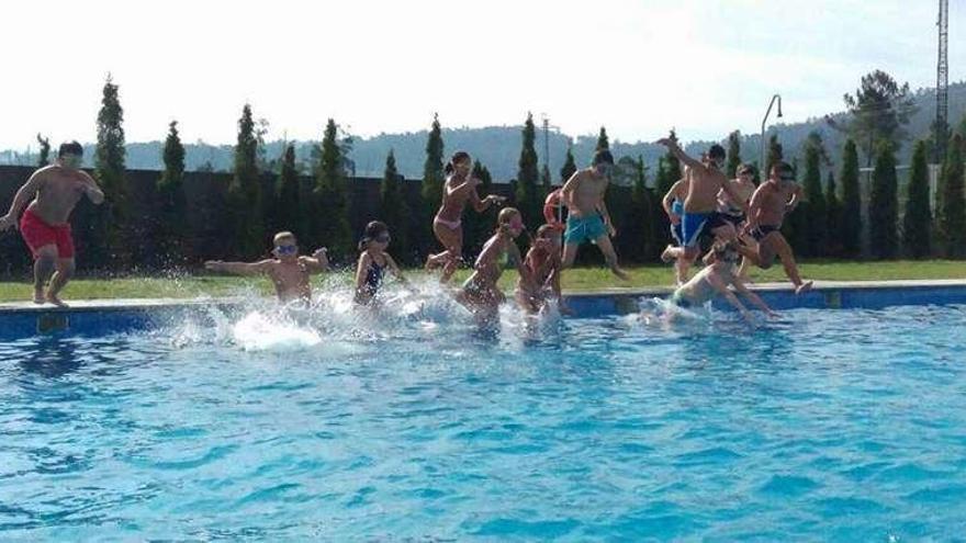 Niños disfrutan en la piscina municipal de Mondariz este verano. // D.P.