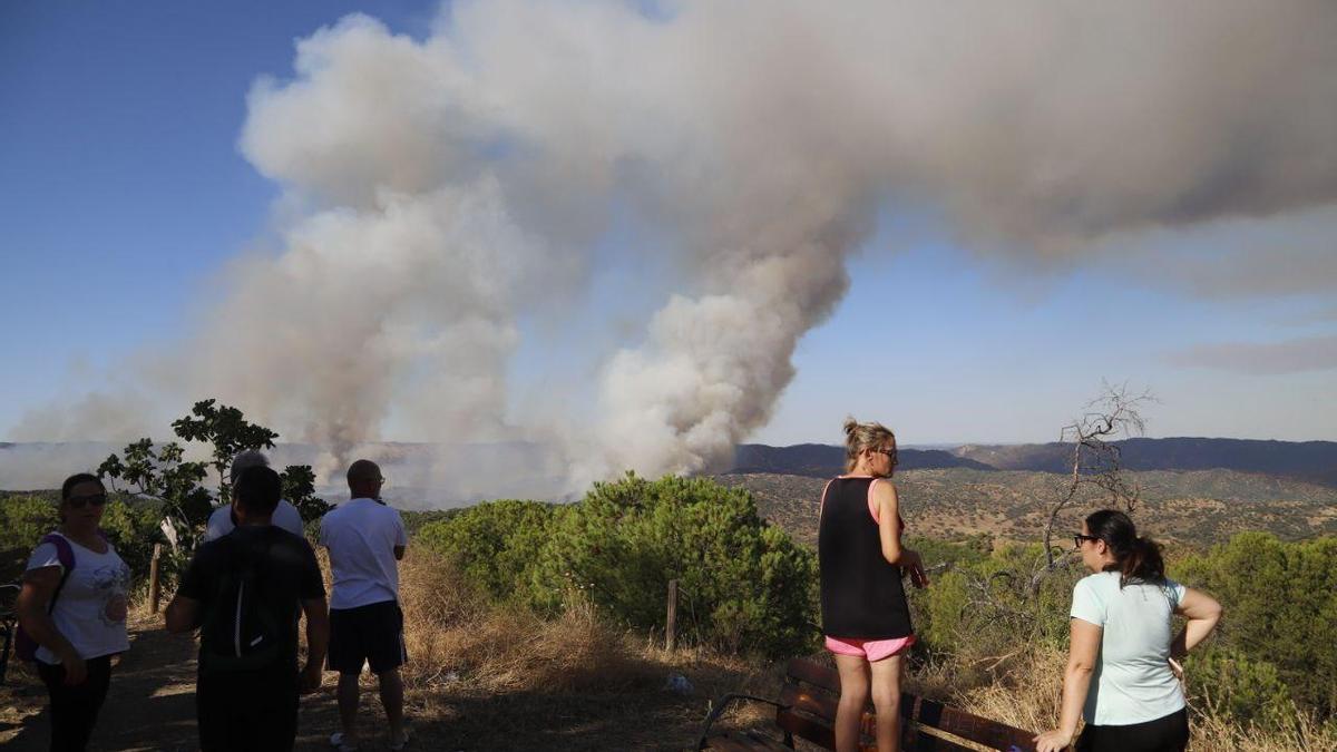 Varios vecinos observan la columna de humo del incendio forestal en Cerro Muriano, este viernes por la tarde.
