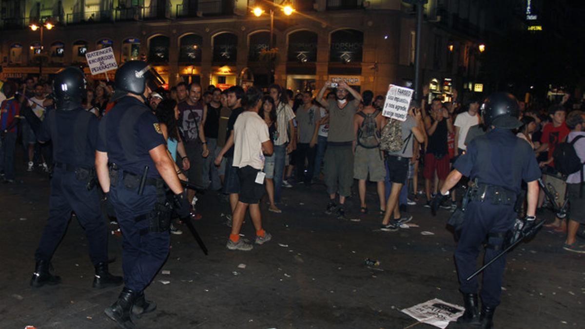 Policías y manifestantes en la Puerta del Sol de Madrid.