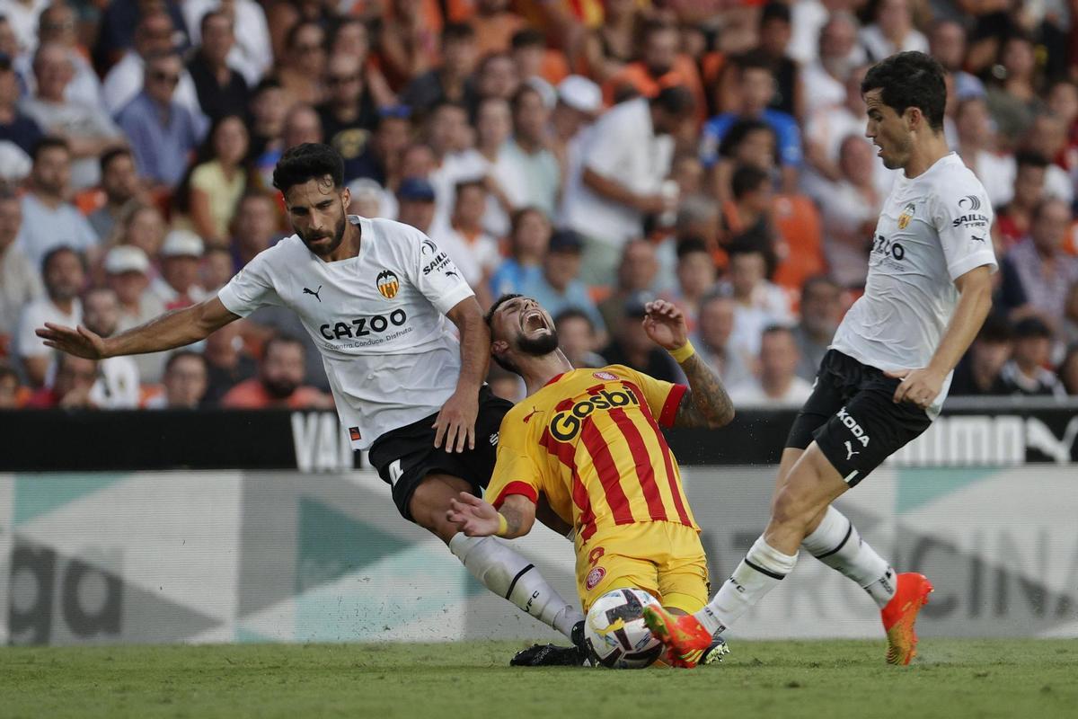 VALENCIA, 14/08/2022.- El delantero chileno del Girona FC Valentín Castellano (c) caetras la entrada del suizo Eray Cümart (i), del Valencia CF, durante el partido de la primera jornada de LaLiga Santander, este domingo en el estadio de Mestalla, en Valencia. EFE/ Manuel Bruque