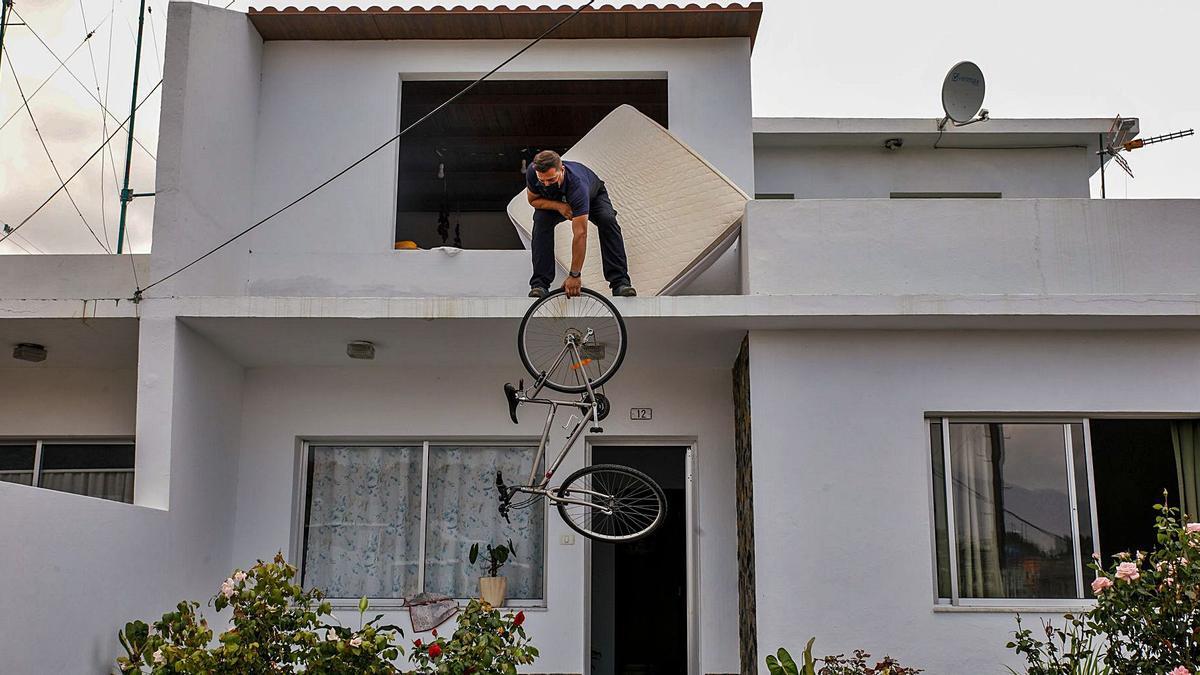 Un hombre saca su bicicleta por la ventana
en el desalojo de su vivienda. | // KIKE RINCÓN / E.P.