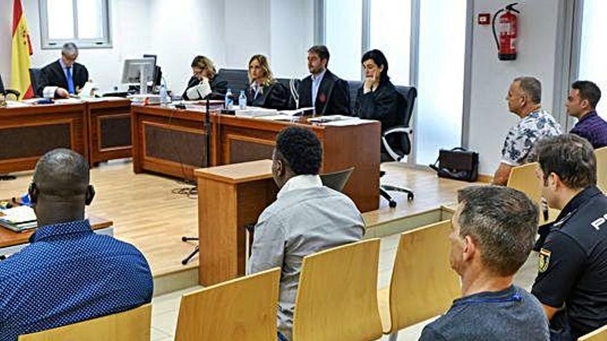 Los cuatro acusados sentados en el banquillo al inicio del juicio.