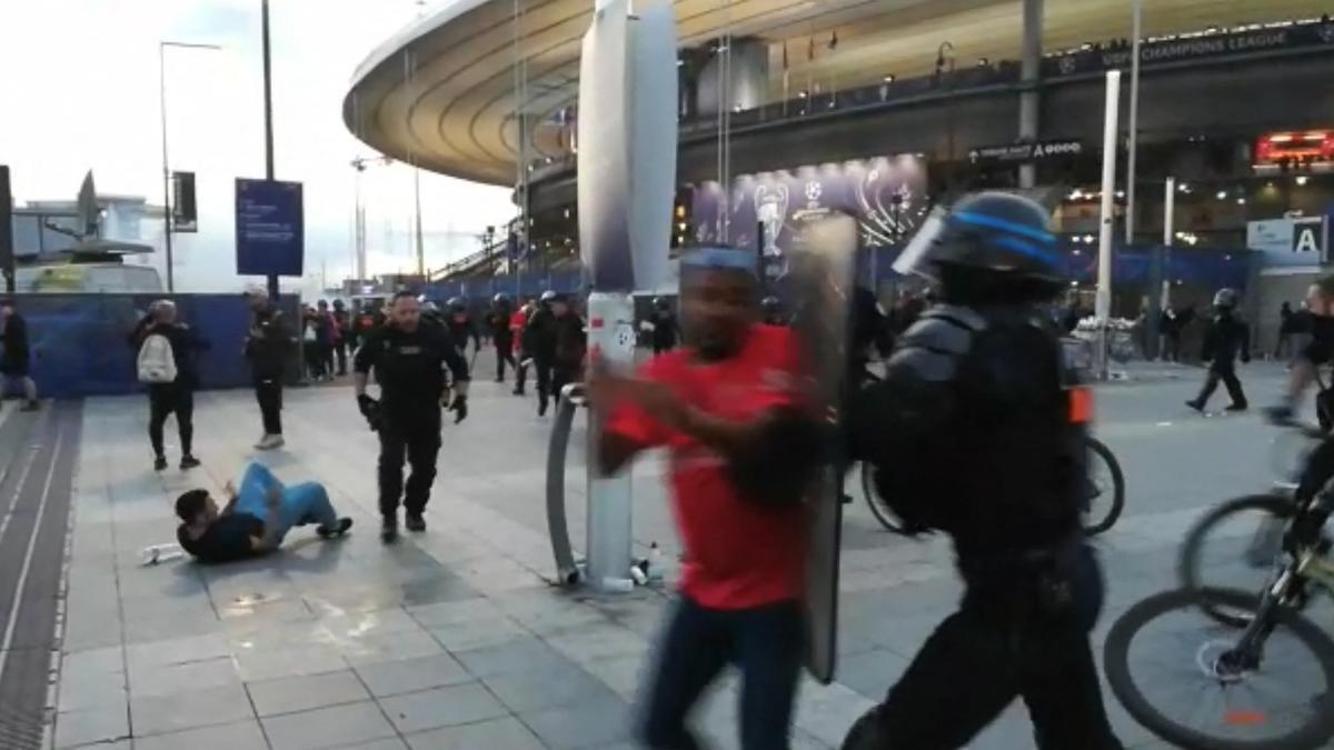 Esta captura tomada de un video de AFP muestra a la policía interviniendo mientras los fanáticos trepan la valla del Stade de France antes del partido de fútbol final de la UEFA Champions League