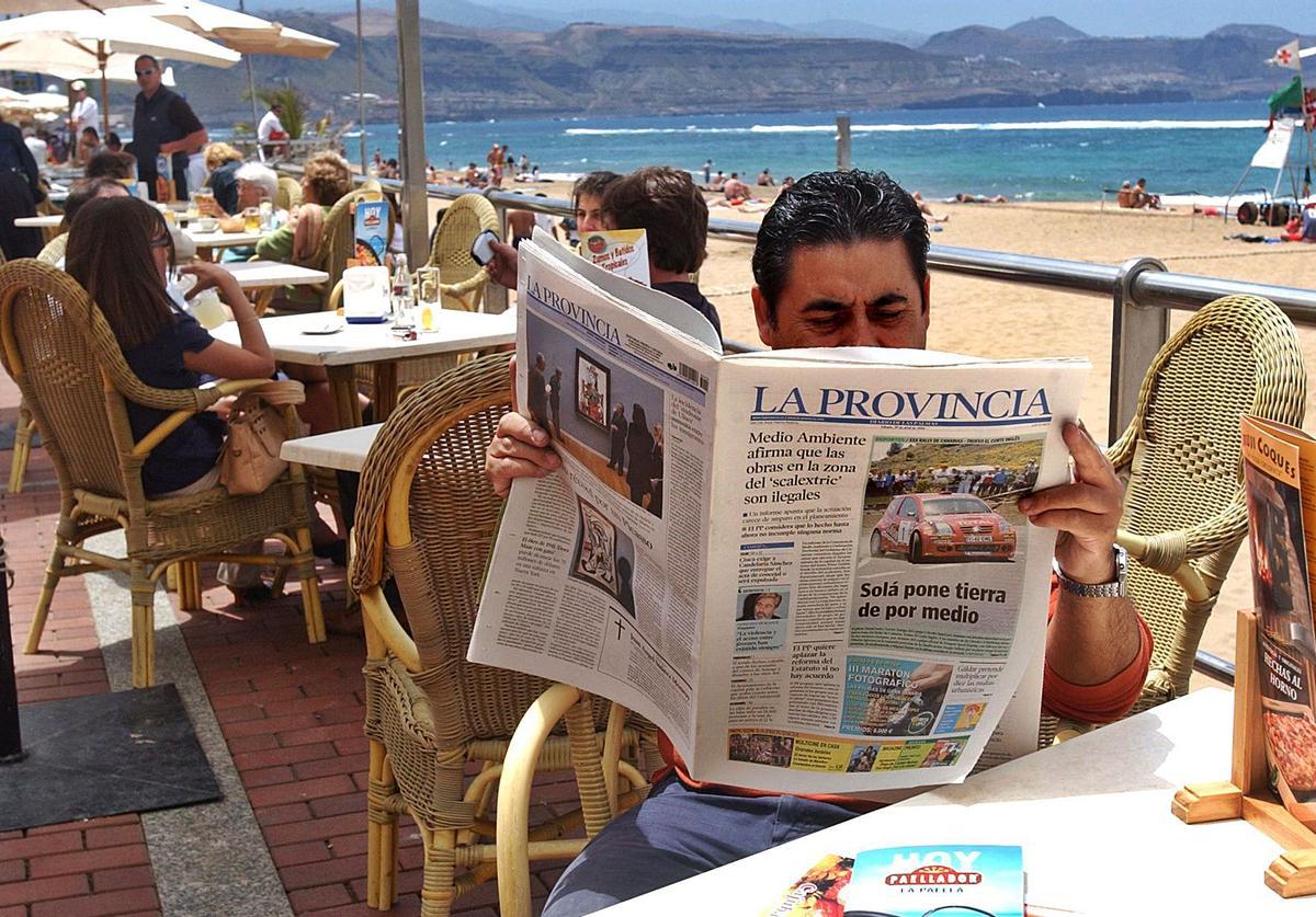 Un lector de LA PROVINCIA/Diario de Las Palmas en una terraza del paseo de  Las Canteras en 2006.