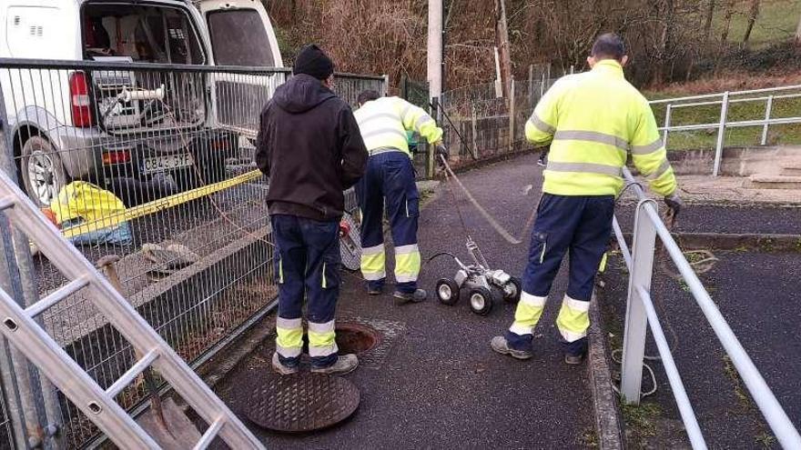 Operarios trabajando con el robot dotado de cámara en uno de los socavones de Bimenes.