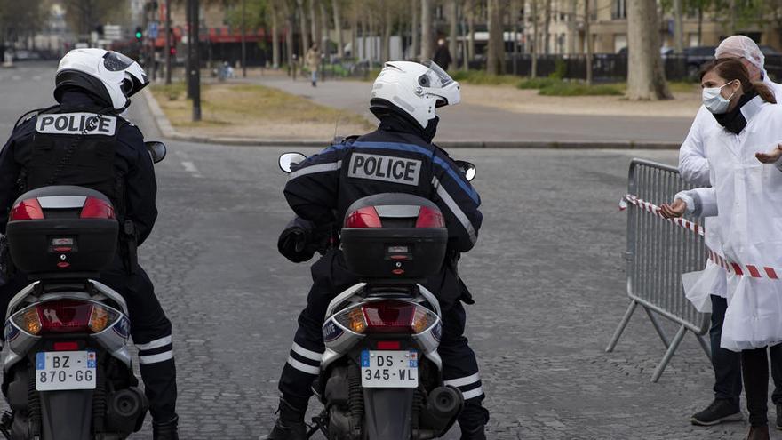 Personal sanitario habla con dos agentes de la policía en París.