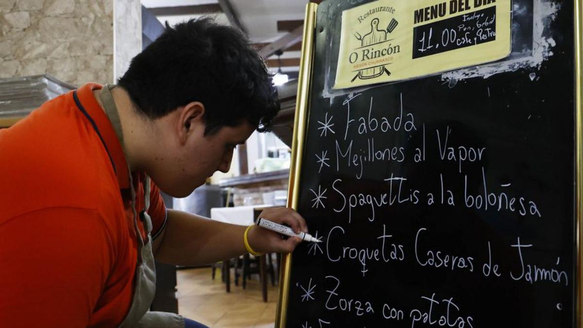 Hans Matías, de O Rincón, haciendo el cartel con su menú.
