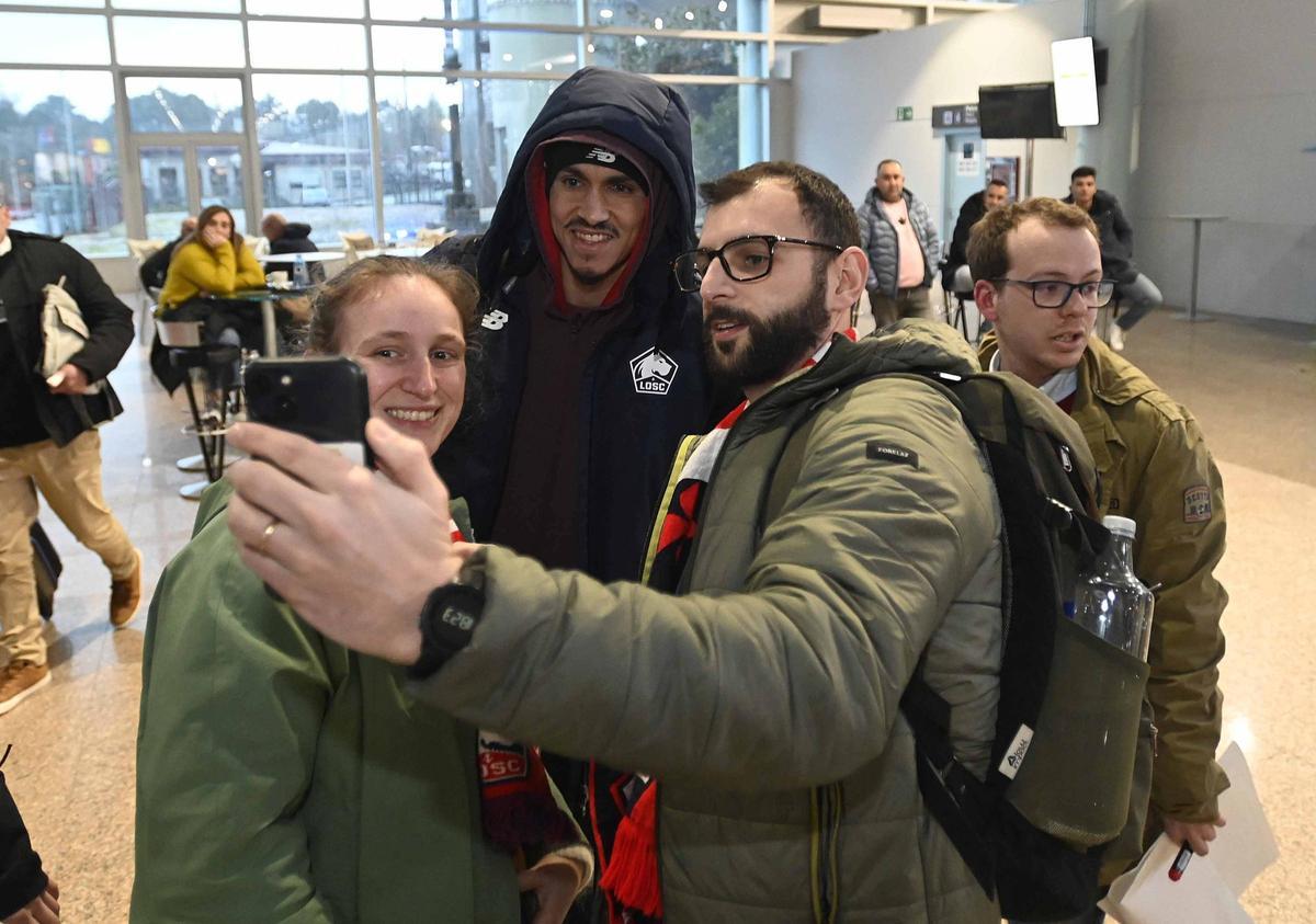 Un jugador del Lille atiende a aficionados y curiosos en el aeropuerto de Peinador