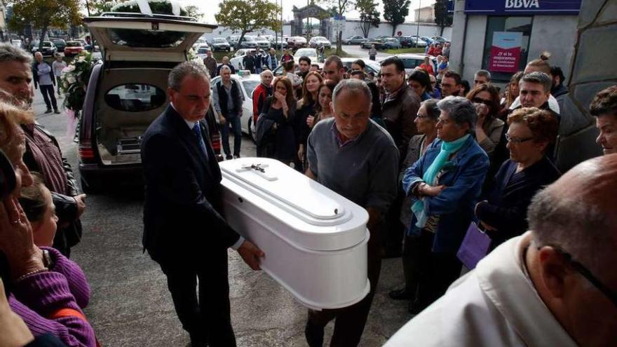 Personal de la funeraria introduce el féretro de Gabriela Bugallo en la iglesia ante la presencia de sus familiares.