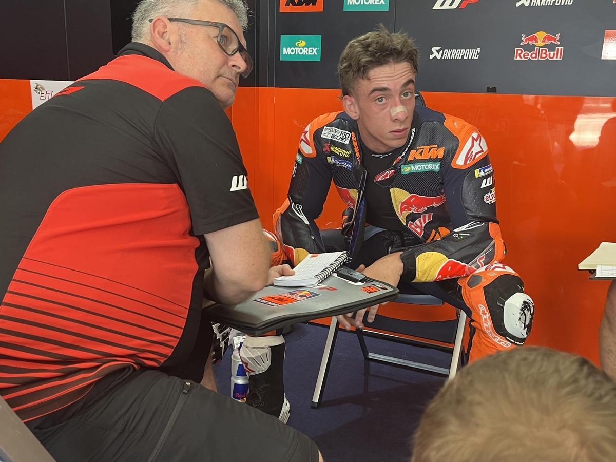Pedro Acosta habla, en el boxe de KTM, con uno de sus técnicos.
