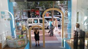 Pequeño jugando en la característica puerta para niños en la tienda de Imaginarium de calle León XIII.