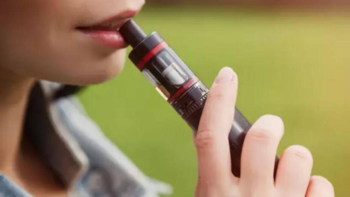 Una mujer fuma un cigarrillo electrónico.