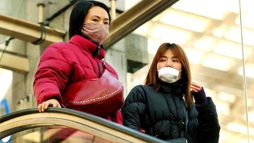 Dos mujeres se protegen con mascarilla en Shanghái en 2003.