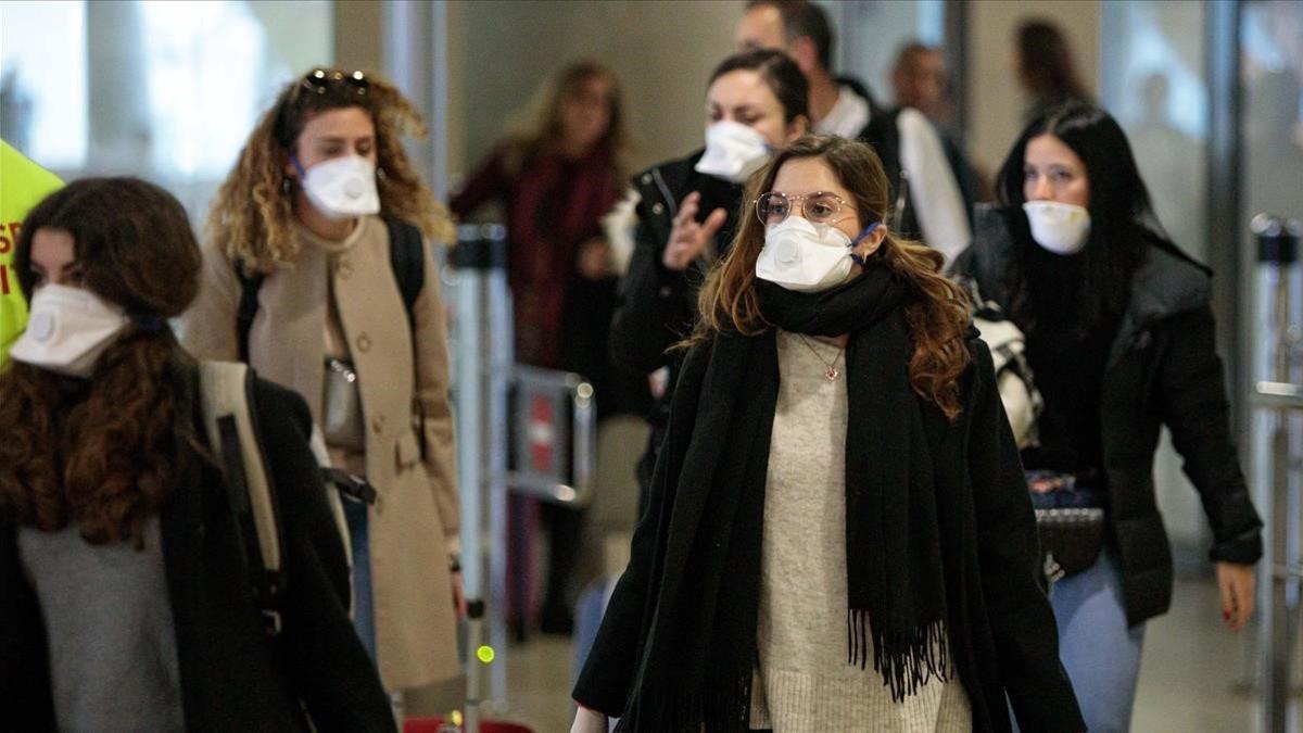 Viajeros procedentes de Italia protegidos con mascarillas a su llegada al aeropuerto de Manises (València), el 25 de febrero del 2020