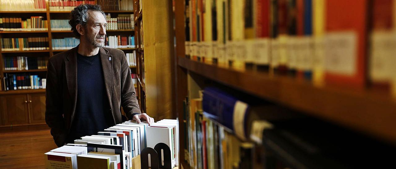 Ricardo Menéndez Salmón, entre libros, en la biblioteca de la Junta General del Principado, posando para LA NUEVA ESPAÑA.