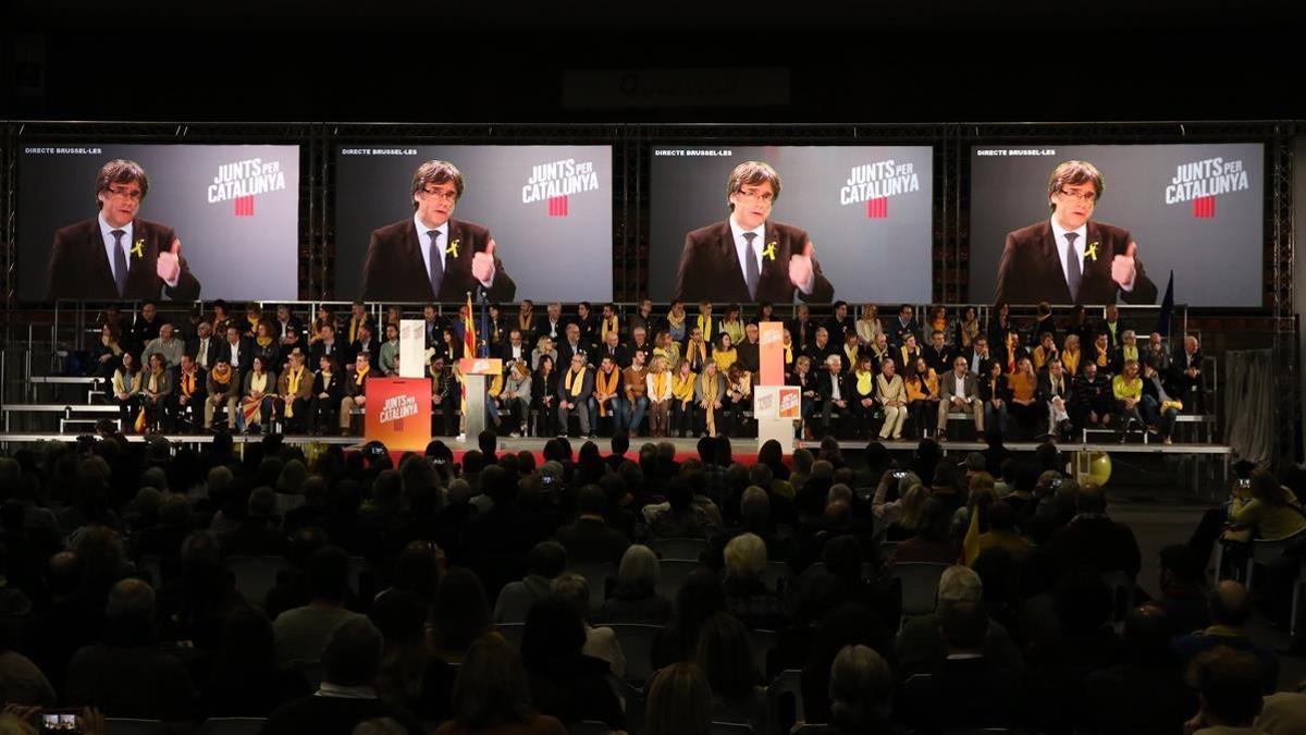 Carles Puigdemont, en las pantallas del mitin del acto central de la campaña de Junts per Catalunya, en Barcelona.
