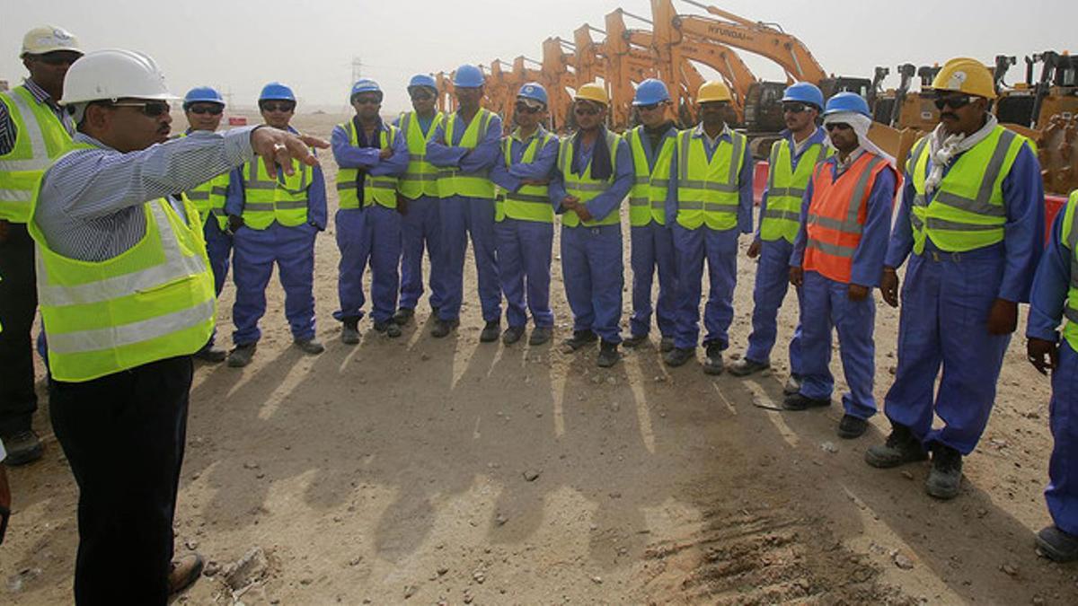 Un grupo de obreros atienden a las explicaciones del capataz antes de proseguir con la construcción del estadio de Al-Wakrah