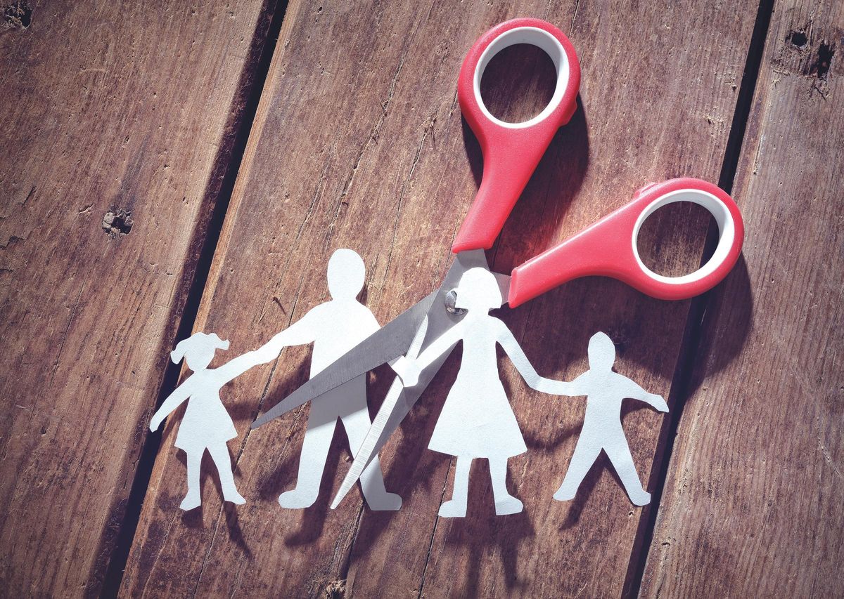 Imagen que simboliza la ruptura de una familia tras un proceso de divorcio. Divorce and child custody scissors cutting family apart / TIJERAS. FIGURAS DE PAPEL