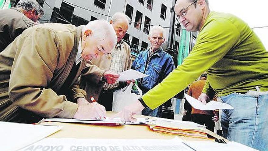 Los representantes de la Federación de Vecinos recogen firmas en el mercadillo dominical de Mieres.