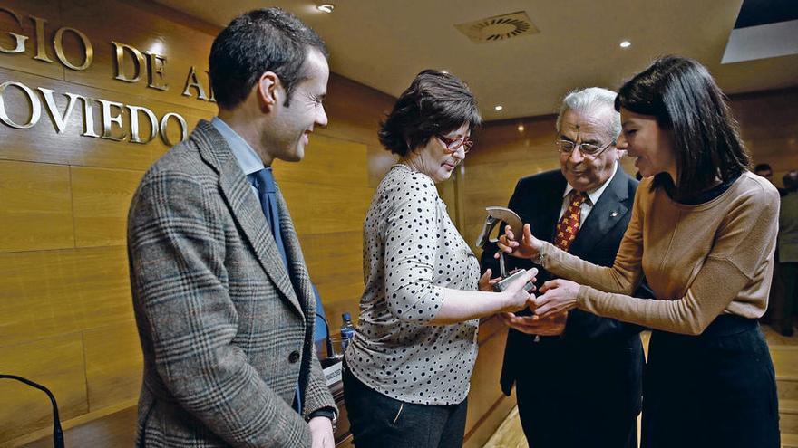 Ramón Fernández-Mijares y María José Moreno reciben, ayer, de manos de María López-Castro, a la derecha, la estatuilla que reconoce a su hijo como agrupado de honor de la Agrupación de Abogados Jóvenes. A la izquierda, Ignacio Cuesta observa la escena.