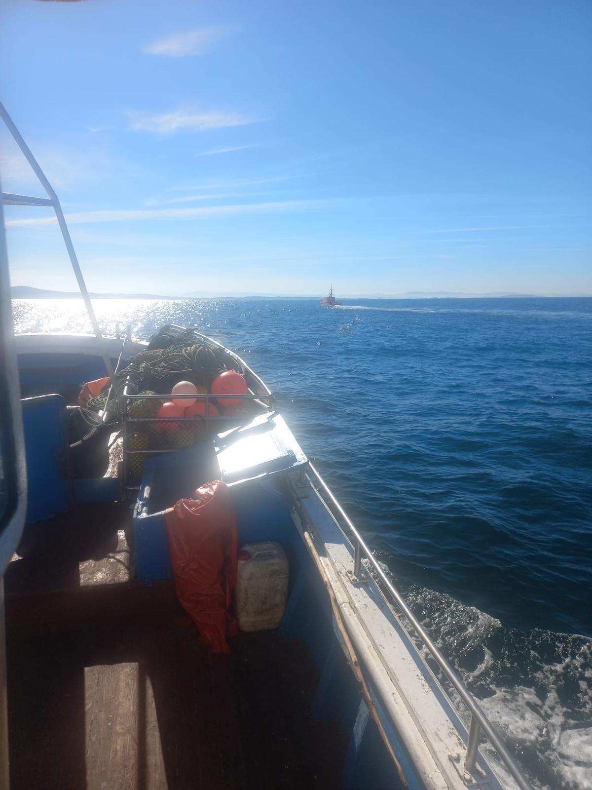 Momento en el que el pesquero es remolcado rumbo al puerto de Aguiño