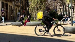 Un repartidor pedalea por la plaza de Consell de Cent con Girona, el miércoles