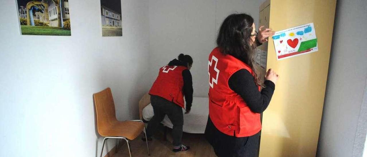 Voluntarias de Cruz Roja de Vilagarcía acondicionan una de las habitaciones para los transeúntes. // Iñaki Abella