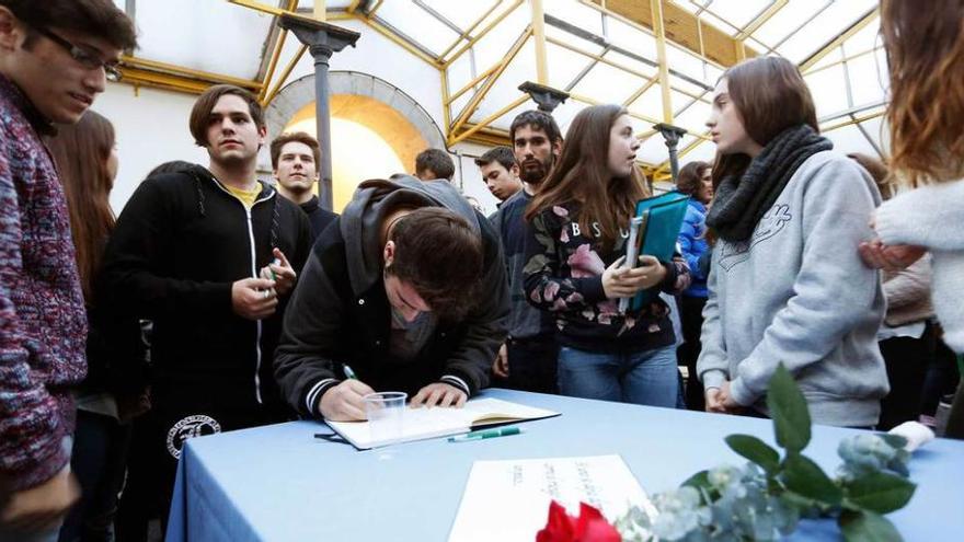 Asistentes, ayer, al homenaje a Hipólito Vacchiano firman un libro para recordar la figura del profesor, en el recuadro.