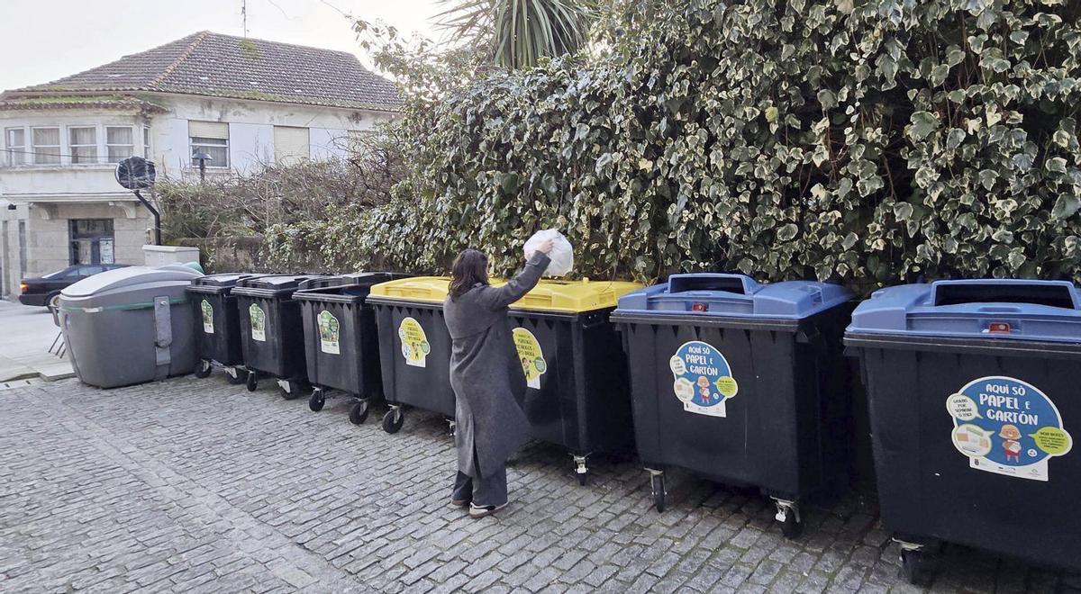 Una vecina deposita residuos plásticos en el contenedor amarillo en el centro urbano de Gondomar.