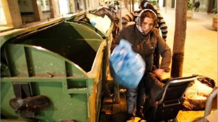 Una dona recull restes d&#039;aliments a la sortida d&#039;un supermercat de Girona en una imatge del desembre passat.