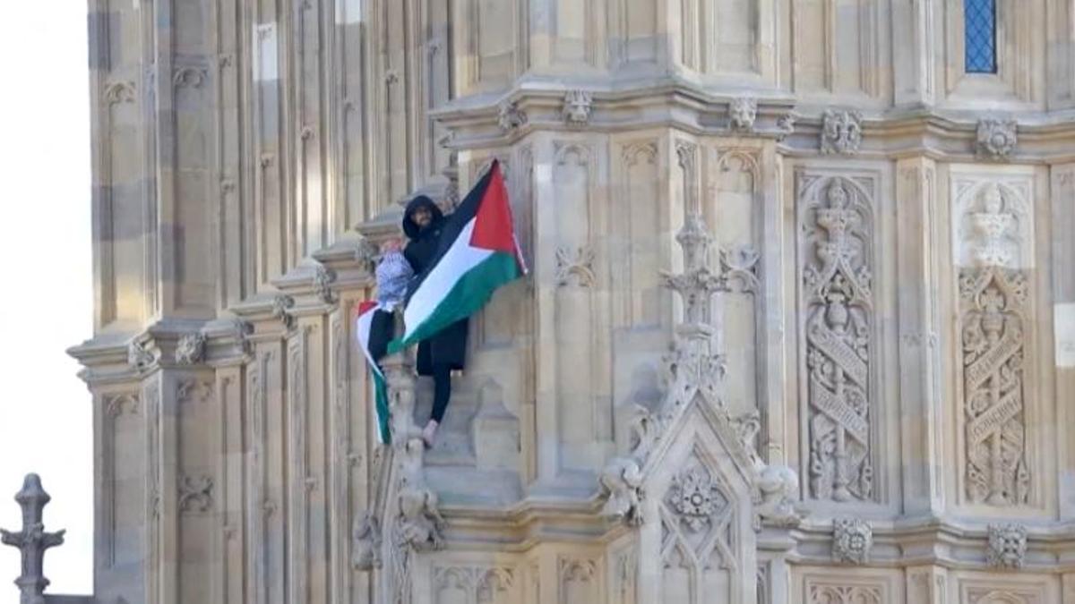Un hombre trepa la torre del Big Ben con una bandera de Palestina