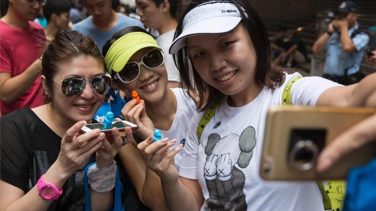 Tres jóvenes se hacen un selfi en Hong Kong.