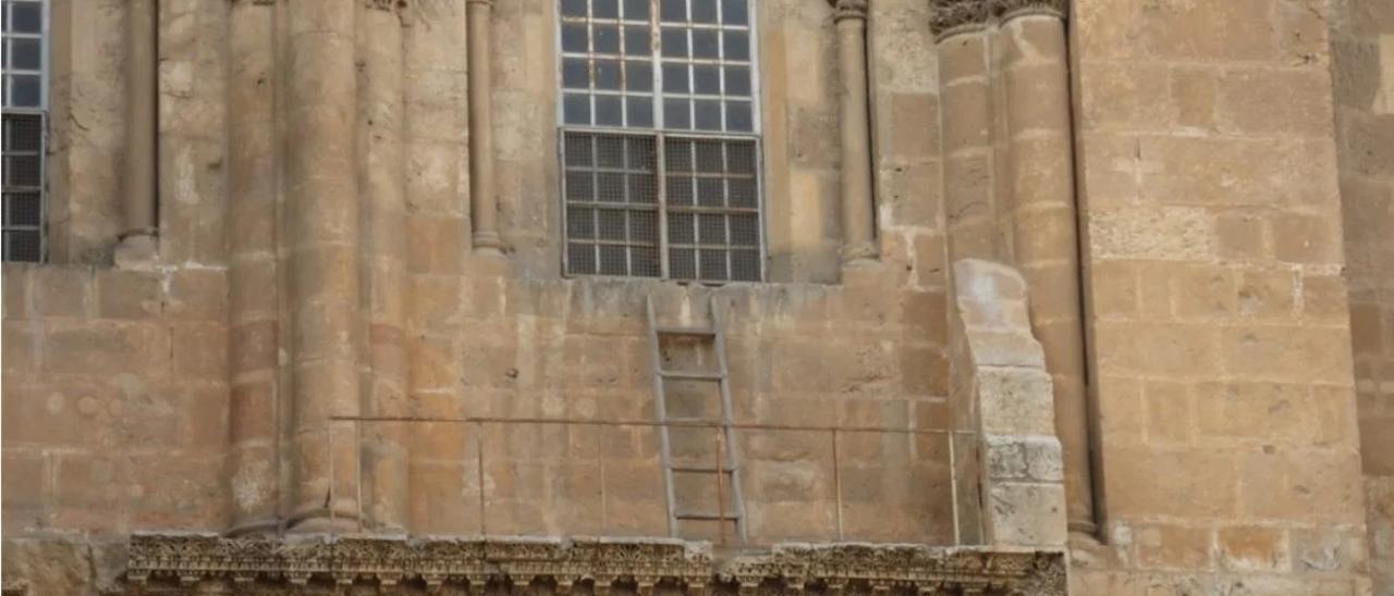 Puerta de acceso al Santo Sepulcro con la escalera inamovible en la ventana.