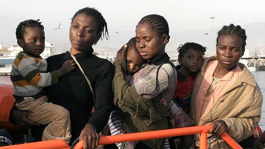 Algunas de las mujeres que viajaban en la patera ocupada por 74 inmigrantes subsaharianos y que ha sido interceptada a unas ocho millas al sudeste del Cabo Sacratif, sostienen a sus bebés a su llegada esta tarde al puerto de Motril.