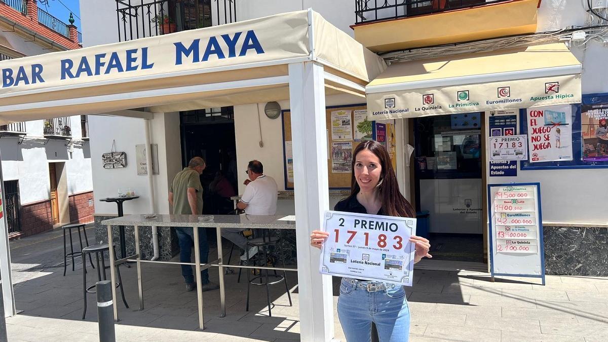 Isabel María Gómez, ante el punto de venta de loterías del bar Rafael Maya de La Rambla, con un cartel del número premiado.
