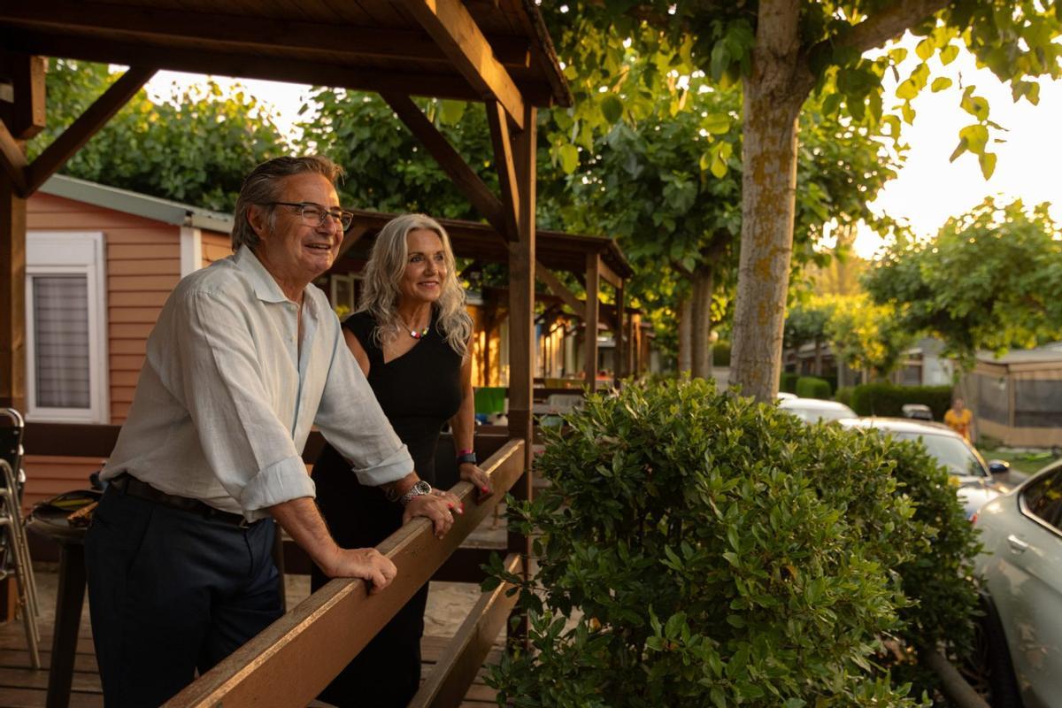 Dos personas observan la puesta de sol en el Camping Prades Park, en Tarragona, que tiene una alta demanda para este agosto.