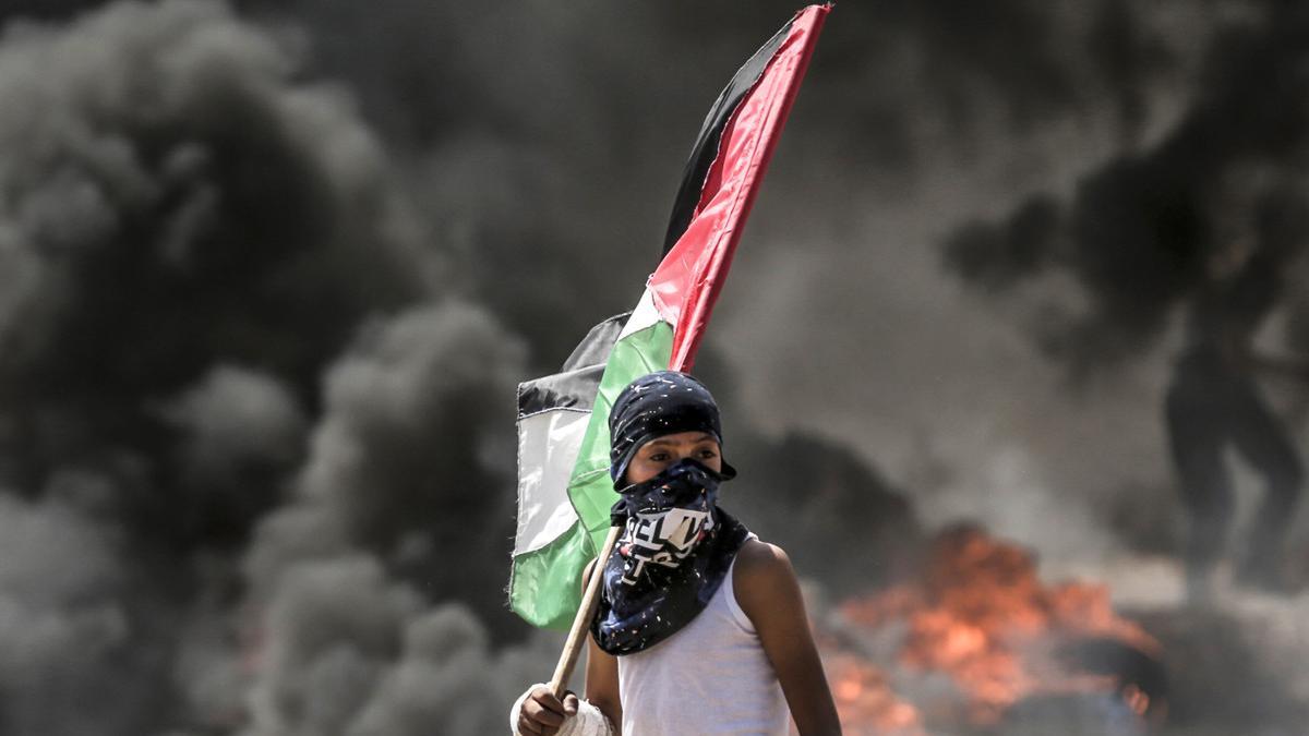 Un niño con la bandera palestino durante los choques con el Ejército israelí en la frontera de Gaza.