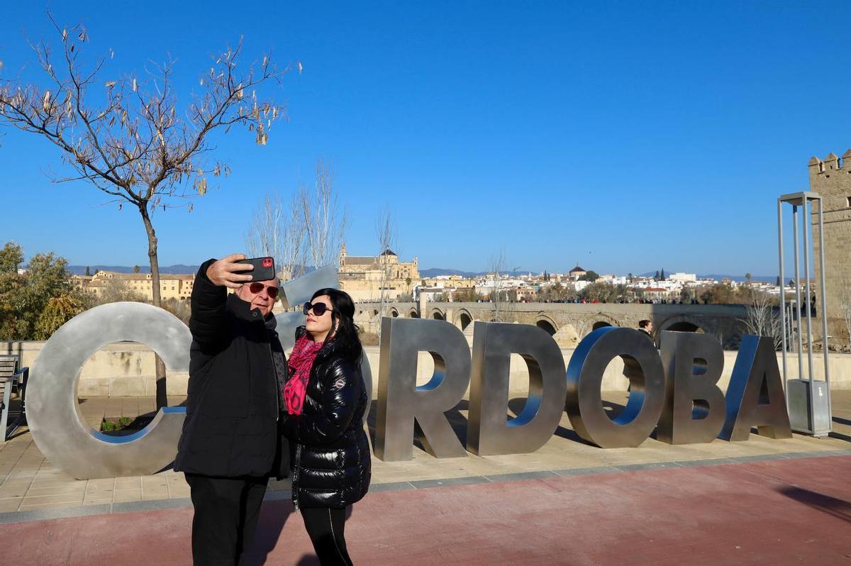 Una pareja se toma una foto con el letrero.